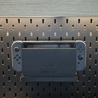 Nintendo Switch rangée sur son support fixé au panneau IKEA SKÅDIS noir