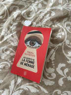 Cœur blanc du marque-page dépassant d'un livre fermé posé sur un lit